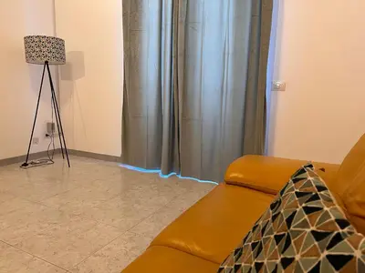 a living room with a couch and a lamp at Attico Giusy in Balestrate