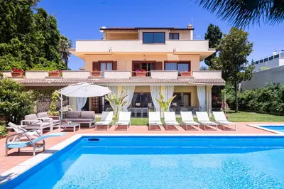 a villa with a swimming pool and a house at Villa Castelforte, con piscina a Mondello in Palermo
