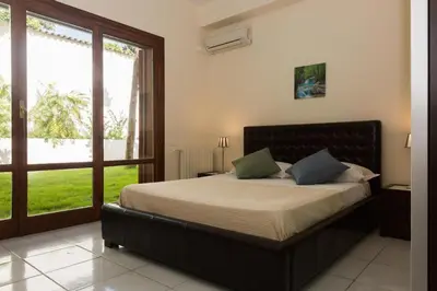a bedroom with a bed and a large window at Villa Castelforte, con piscina a Mondello in Palermo