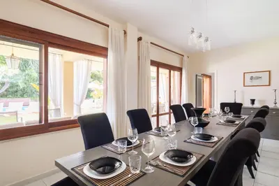 a dining room with a long table and chairs at Villa Castelforte, con piscina a Mondello in Palermo