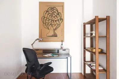 a desk with a chair next to a book shelf at Cala & Cassari View By DomuSicily in Palermo