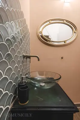 a bathroom with a glass sink and a mirror at Cala & Cassari View By DomuSicily in Palermo