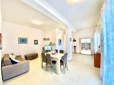 a living room with a table and a couch at Villa dei Gerani, a 500 mt dal mare in Alcamo