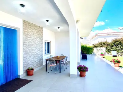 a patio with a table and chairs on it at Villa dei Gerani, a 500 mt dal mare in Alcamo