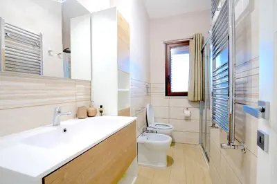 a bathroom with a white sink and a toilet at Private Villa, Sun & Pool in Mandra Capreria