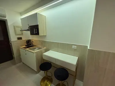 a small kitchen with two stools and a sink at Cappellieri centro apartament in Palermo