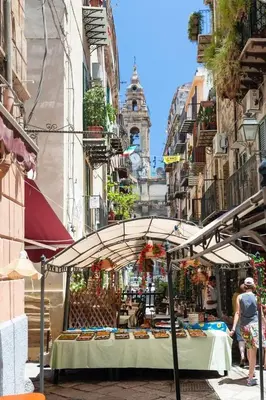 a market with a table with food on a street at Cappellieri centro apartament in Palermo
