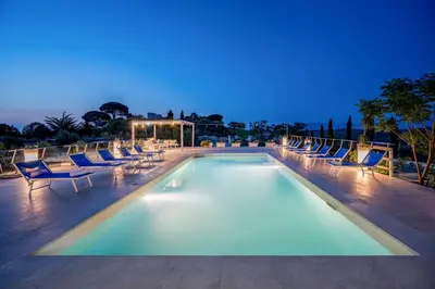 a swimming pool with lounge chairs and a swimming poolvisor at Villa Sikelia con fantastica piscina in Alcamo