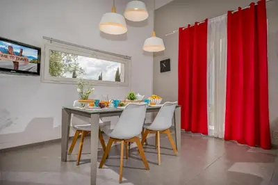 a dining room with red curtains and a table with chairs at Villa Sikelia con fantastica piscina in Alcamo