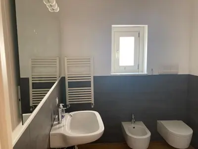 a white bathroom with a sink and a toilet at Dai Pupi al 68 in Palermo