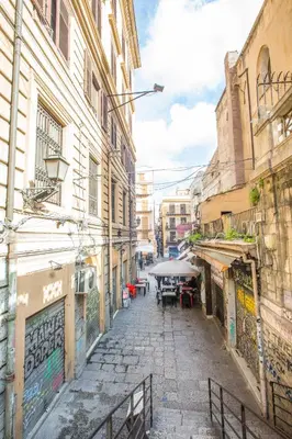 an alley with tables and umbrellas on a city street at La Bucceria in Palermo