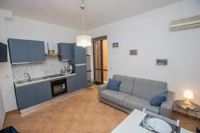 a living room with a couch and a kitchen at La Bucceria in Palermo