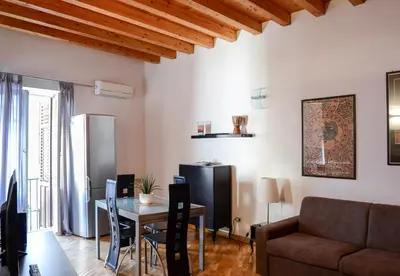 a living room with a table and a couch at Appartamento moderno tra Stazione, Via Maqueda e Ballarò in Palermo