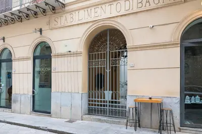 a store front with two stools in front of a building at GuestHost - Casa Giacomo in central Palermo in Palermo