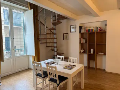 a dining room with a white table and chairs at La casa delle stelle in Palermo
