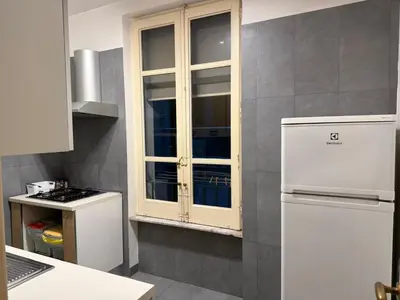a kitchen with a white cabinet and a refrigerator at La casa delle stelle in Palermo