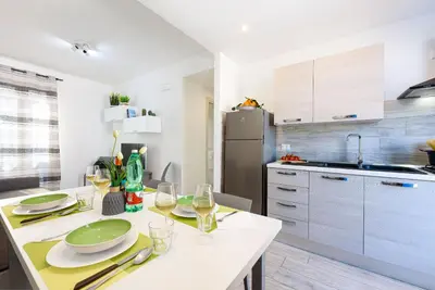 a kitchen with a table with plates and wine glasses at Panarea SVLC in San Vito lo Capo