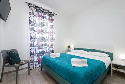 a bedroom with a blue bed and a curtain at Panarea SVLC in San Vito lo Capo