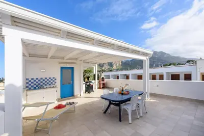 a patio with a blue table and chairs at Panarea SVLC in San Vito lo Capo