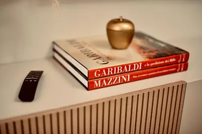 three books sitting on a table with a apple on top at Dimora Beatrice in Termini Imerese