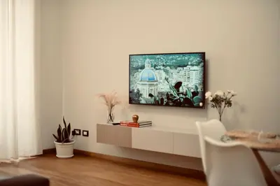 a living room with a tv on a white wall at Dimora Beatrice in Termini Imerese