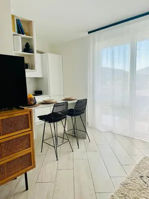 a kitchen with two chairs and a table with a tv at Comfy Holiday House in Castellammare del Golfo