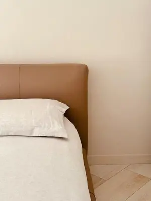 a bed with a white pillow on top of it at Comfy Holiday House in Castellammare del Golfo