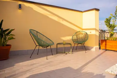 two chairs and a table on a patio at Solemar Sicilia - Casa Alba in Santa Flavia