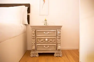a gray nightstand with a drawer next to a bed at Solemar Sicilia - Casa Alba in Santa Flavia