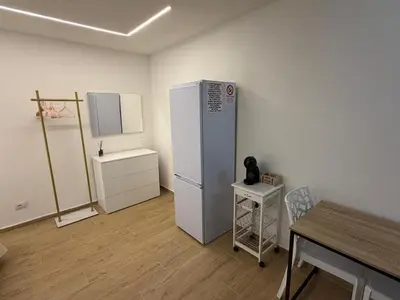a room with a refrigerator and a table in it at A casa del capo in Palermo