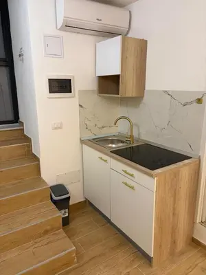 a small kitchen with a sink and a staircase at A casa del capo in Palermo