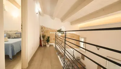 a corridor of a room with a bed and a staircase at Charming Loft near the Sea - Castellammare del Golfo by Sicily Home Solutions in Castellammare del Golfo