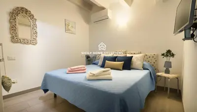a bedroom with a blue bed with towels on it at Charming Loft near the Sea - Castellammare del Golfo by Sicily Home Solutions in Castellammare del Golfo