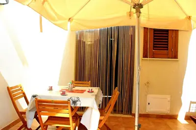 a dining room with a table and an umbrella at Appartamento Calvino piano terra in via Mulino 31 in San Vito lo Capo