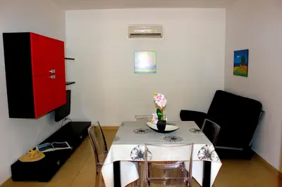 a dining room with a table and a red cabinet at Appartamento Calvino piano terra in via Mulino 31 in San Vito lo Capo