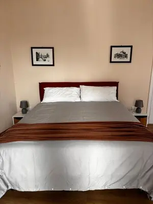 a large bed in a bedroom with two pictures on the wall at Casa Rubino al Massimo in Palermo