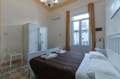 a bedroom with a large bed and a window at Casa Botanica Apartment in Palermo