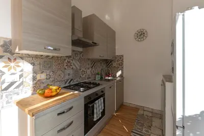 a kitchen with a stove and a bowl of fruit on the counter at Casa Botanica Apartment in Palermo