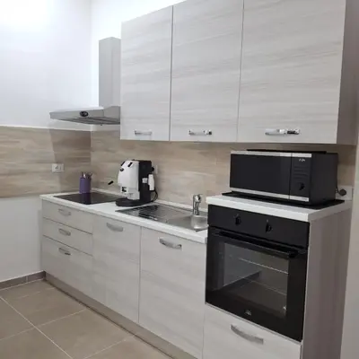 a kitchen with white cabinets and a black appliance at Casa Bruno in Palermo