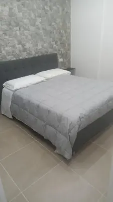 a bed in a bedroom with a brick wall at Casa Bruno in Palermo