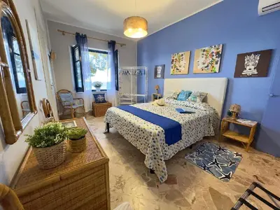 a bedroom with a bed and a blue wall at Sicily Sea Villa Capo Zafferano in Santa Flavia