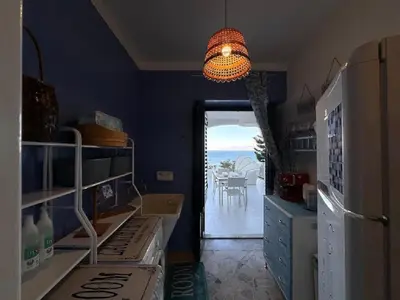 a kitchen with a refrigerator and a chandelier at Sicily Sea Villa Capo Zafferano in Santa Flavia