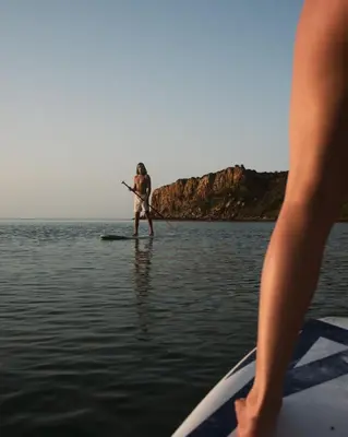 a man on a paddle board in the water at Sicily Sea Villa Capo Zafferano in Santa Flavia