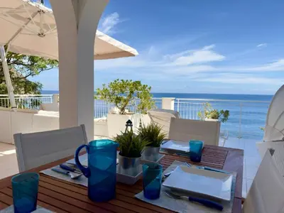 a table with blue vases sitting on top of a patio at Sicily Sea Villa Capo Zafferano in Santa Flavia