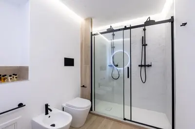 a bathroom with a shower with a toilet and a sink at Casabea in Palermo