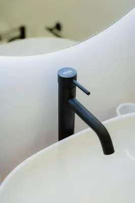 a black pipe sticking out of a white table at Casabea in Palermo