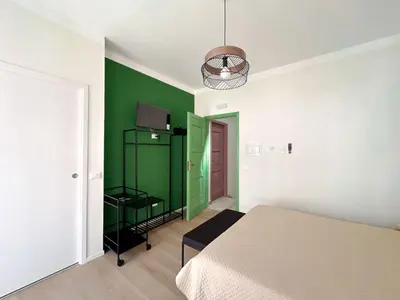 a room with a bed and a green wall at Cielo D'Alcamo Palazzo Antichi Quartieri in Alcamo