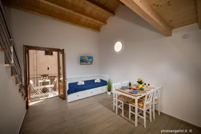 a room with a bed and a table with chairs at Borgo La Chiusa in Castellammare del Golfo