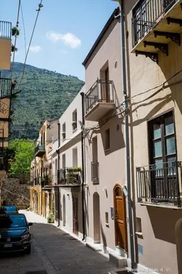 an alley with buildings and a car parked on the street at Borgo La Chiusa in Castellammare del Golfo