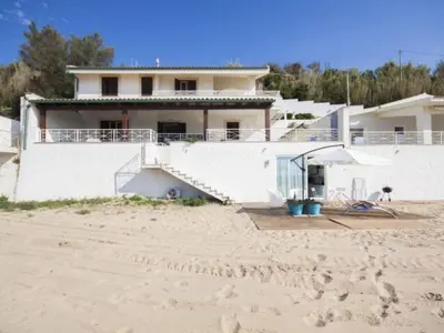 a house on the beach next to a sandy beach at Apartment Villa am Meer Trappeto by Interhome in Trappeto
